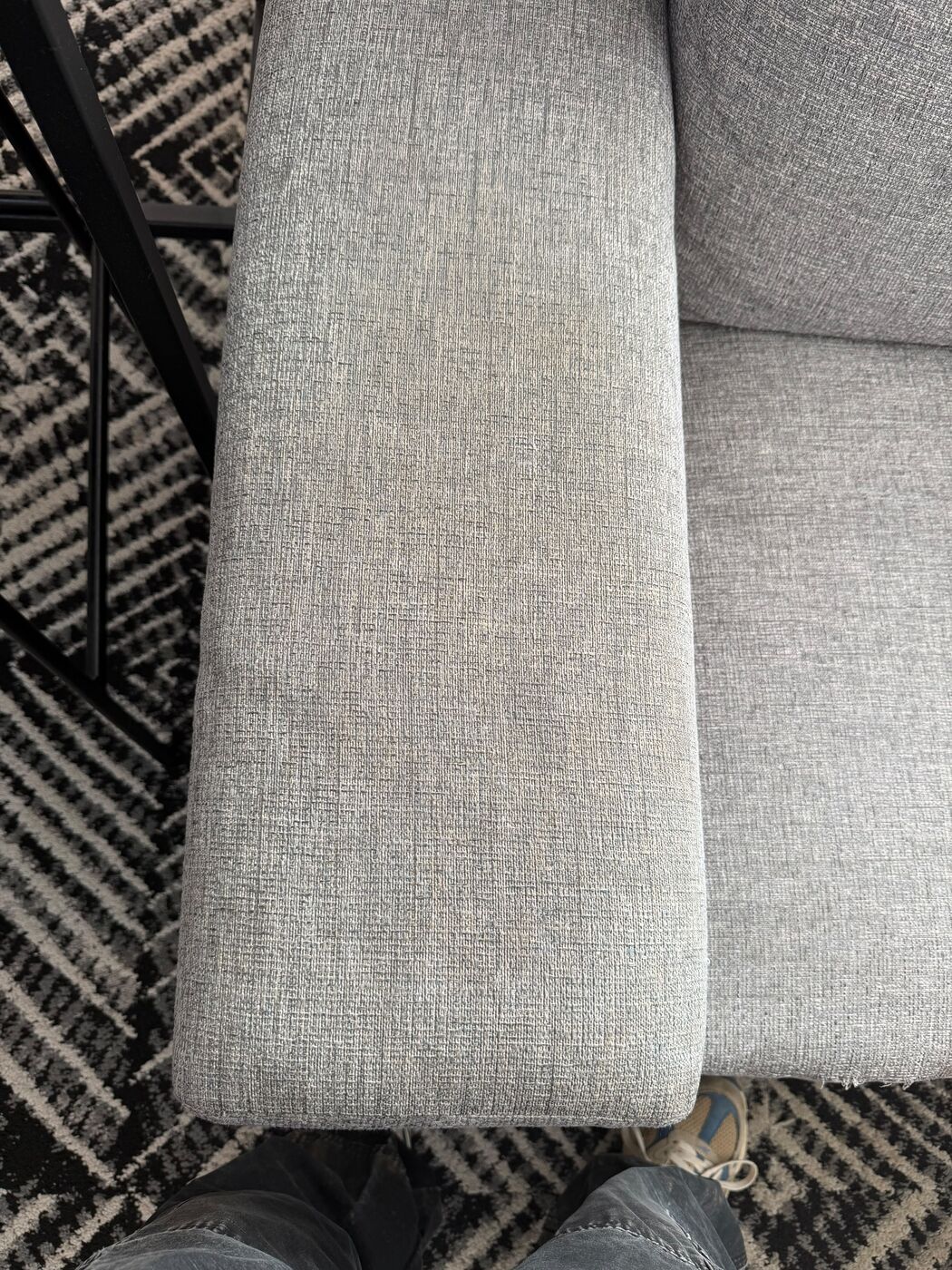 Grey upholstered sofa cushion being cleaned